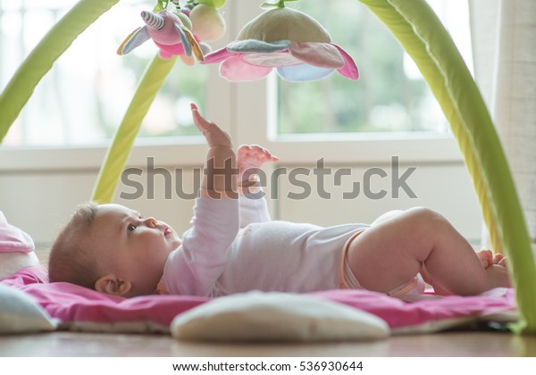 ぶら下がりおもちゃで遊ぶ幸せな赤ちゃん の写真素材 今すぐ編集