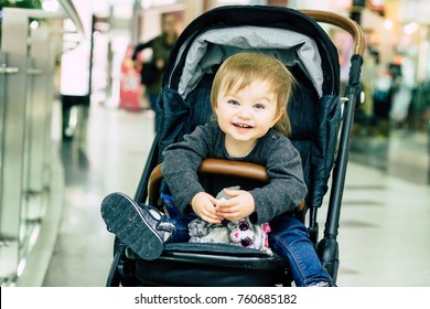 Happy Baby Sitting In A Stroller In Shopping Mall