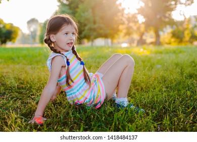Happy baby standing upside down on green grass in summer Park. The concept of a healthy lifestyle. The fun and carefree childhood