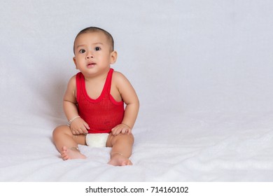 Happy Baby Wearing Red T-shirt.Cute Kids In A Good Mood Sit Down On The Couch