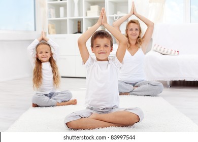 Happy Balanced Life - Woman And Kids Doing Yoga Exercise At Home - Focus On Boy