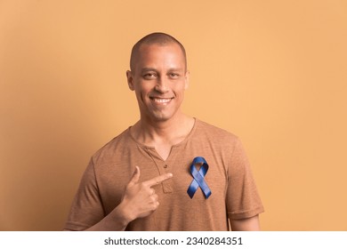 happy bald man showing blue ribbon in all beige colors. prostate cancer, awareness concept. - Powered by Shutterstock