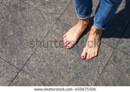 Happy barefoot legs in city, top view