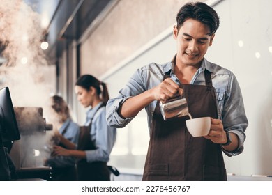 Happy barista Asia man make coffee with team work background at coffee shop	 - Powered by Shutterstock