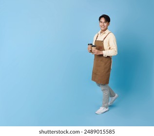 Happy barista asian man serving customer holding coffee cup at coffee shop isolated on blue copy space background. - Powered by Shutterstock