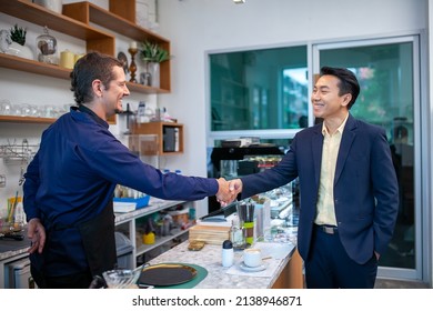 happy barista take order with tablet from customer in coffee shop. restaurant owner and customer shake hands. - Powered by Shutterstock