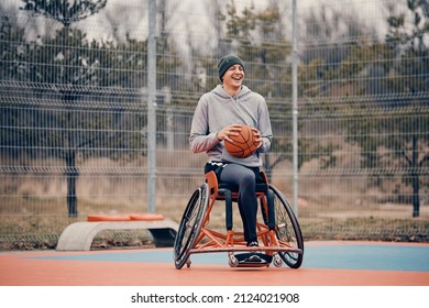 Happy Basketball Player With Disability Uses Wheelchair While Playing On Outdoor Sports Court. 