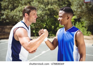 Happy basketball player holding hands while standing in court - Shutterstock ID 678808369
