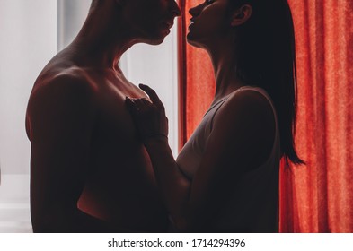 Happy To Be In Love. Beautiful Young Couple Sitting Face To Face And Smiling While Resting In The Beach Hut. Couple In Love. Sensual. Man And Woman Posing. Sensuality. Intimate. Hotel Room. Life. 
