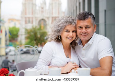 Happy To Be Together. Attractive Older Couple Sitting In Side Walk Cafe.