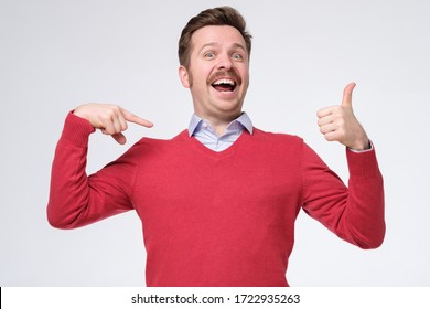 Happy bearded man in red sweater shows himself with thumbs, smiles satisfied happy, pointing oh his chest bragging. I am awesome. Studio shot - Shutterstock ID 1722935263