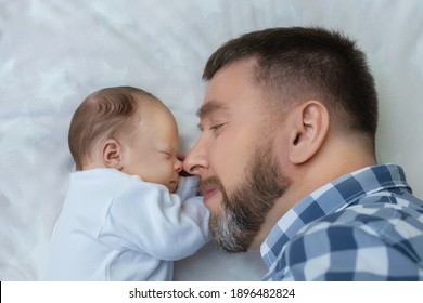 Happy Bearded Middle-aged Father With Newborn Baby Lying In Bed Face To Face, The Concept Of Fatherhood, Father's Day