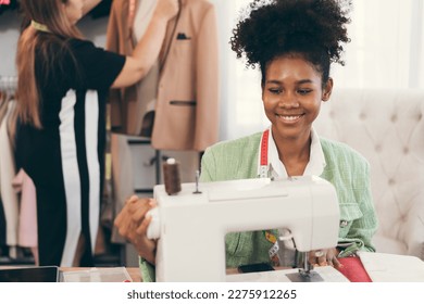 Happy beautiful African American woman fashion designer clothes working with sewing in own dressmaking studio or boutique	 - Powered by Shutterstock