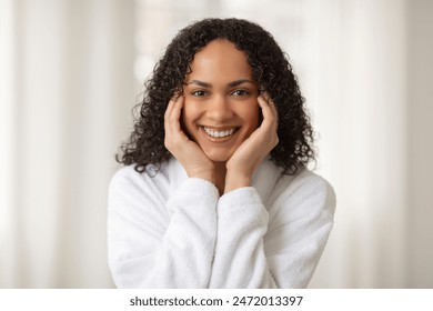 Happy beautiful African American woman pampering her skin in the bathroom, enjoying skin care routine and beauty rituals - Powered by Shutterstock