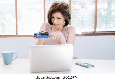 Happy Beautiful Asian Woman Celebrating Birthday At Home With Cake Online Together With Her Friends On Video Call Virtual Party In Quarantine Time. Video Conference. Coronavirus Outbreak.