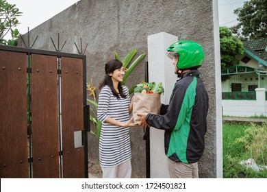 Happy Beautiful Asian Woman Receiving Grocery Delivery At Home