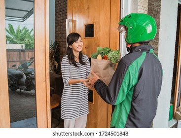 Happy Beautiful Asian Woman Receiving Grocery Delivery At Home