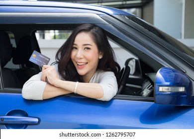 Happy beautiful Asian woman sitting inside new car blue and showing credit card pay for oil, pay a tire, maintenance on the garage, Make payment for refueling car on gas station, Automotive financing - Shutterstock ID 1262795707