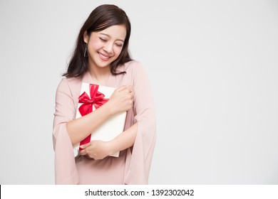 Happy beautiful asian woman smile with red gift box and copy space white living room background. Teenage girls in love, Receiving gifts from lovers. New Year, Christmas and Valentines Day concept - Shutterstock ID 1392302042