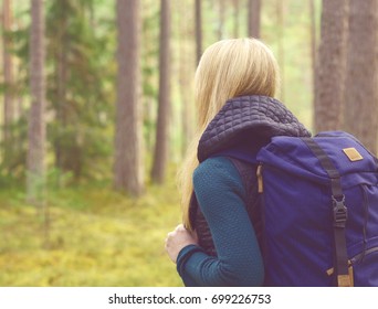 Happy, beautiful blond girl walking in forest and swamps. Camp, tourism, hiking concept.