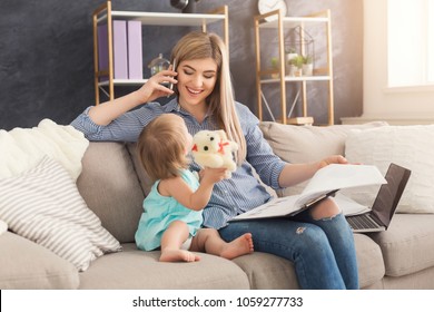 Happy beautiful business mom working with documents and talking on smartphone in home office while her cute baby playing with toys. Business, motherhood, multitasking and family concept. - Powered by Shutterstock