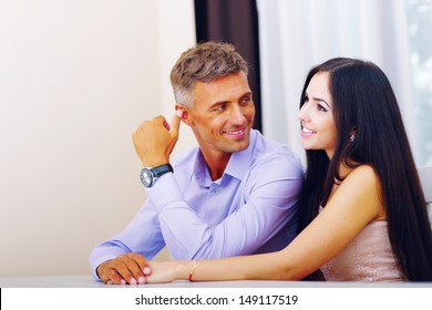 Happy Beautiful Couple Sitting At The Table At Home