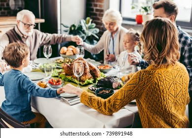 Happy Beautiful Family Praying Before Holiday Dinner On Thanksgiving