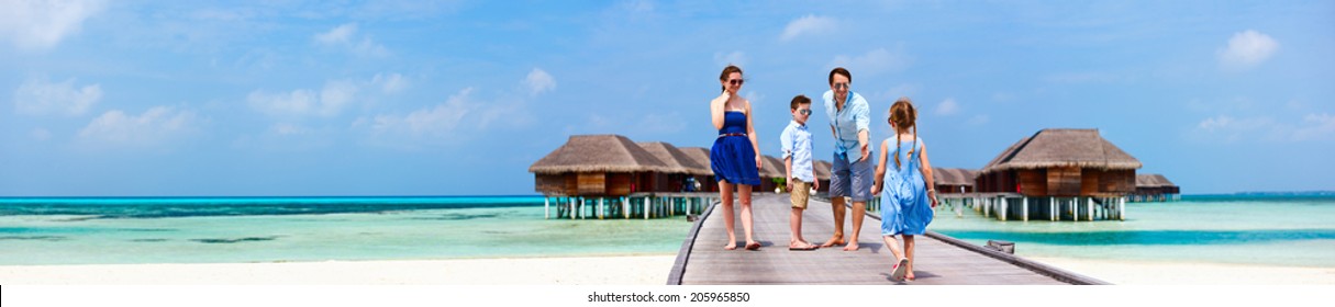 Happy Beautiful Family Walking On Wooden Jetty During Summer Vacation At Luxury Resort Wide Panorama With Copy Space, Perfect For Banners