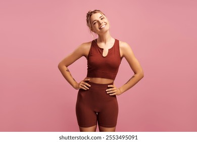 Happy beautiful female coach in sportwear posing in studio, looking at camera, isolated on pink. Sport, health care, wellness concept - Powered by Shutterstock