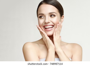 Happy beautiful girl holding her cheeks with a laugh   looking to the side. Pretty woman   clean fresh skin . Expressive facial expressions  .Cosmetology , beauty and Spa
  - Shutterstock ID 748987114
