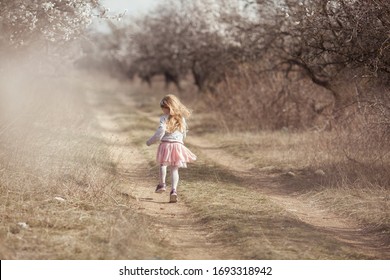 Happy beautiful girl runs in a flowering almond garden, outdoor - Powered by Shutterstock