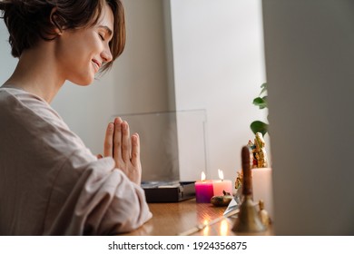 Happy Beautiful Girl Smiling While Praying At Home Shrine Indoors