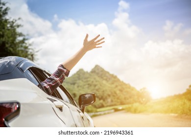 Happy beautiful girl traveling in a hatchback car
