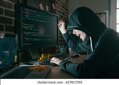 happy beautiful hacker raised hand celebration successful when she finished bad data virus and showing many bitcoin on working desk. - Powered by Shutterstock