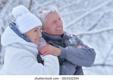 Happy beautiful senior couple posing at winter outdoors