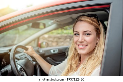 Happy Beautiful Woman Is Driving A Red Car.