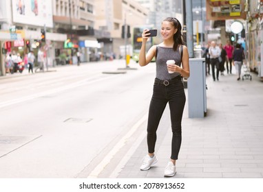 Happy Beautiful Woman Holding Coffee Hot Cup And Taking Photo With Mobile Phone In Central Walking In Streets, Travel Guide, Tourism In Hong Kong. Young Girl Tourist With Smartphone On The Street.