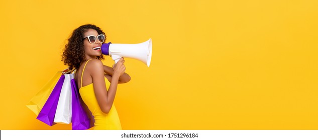 Happy beautiful woman with shopping bags and megaphone on isolated colorful yellow banner background for sale and discount concepts - Powered by Shutterstock