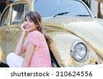 Happy Beautiful Woman Sitting Against Gold Retro Car. 