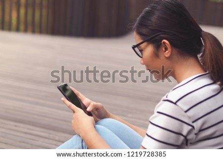 Happy beautiful woman using smart phone outdoors