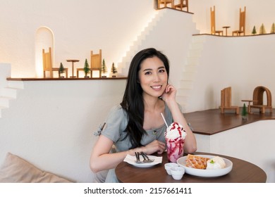 Happy beautiful woman. Young woman with long black hair in a coffee shop during the brunch. Travel and lifestyle. Young girl in cafe. Portrait of beautiful smiling woman in a cafe.