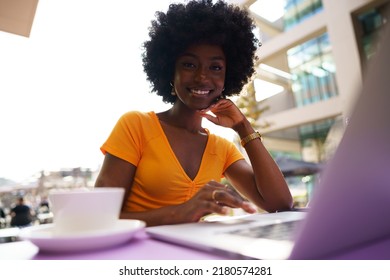 Happy beautiful young black woman using laptop in cafe - Shutterstock ID 2180574281