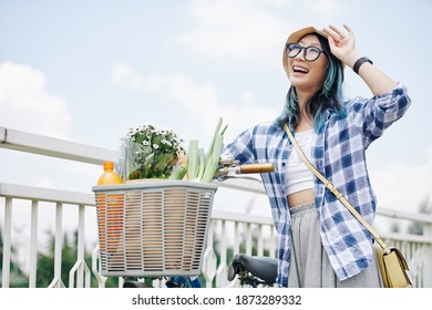 Happy Beautiful Young Chinese Woman With Blue Hair Standing Next To Bicycle With Groceries In Front Basket