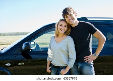 Happy Beautiful Young Couple Standing Near The Car