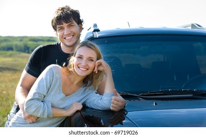 Happy Beautiful Young Couple Standing Near The Car