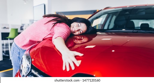 Happy Beautiful Young Woman Buying A New Car At The Car Showroom.