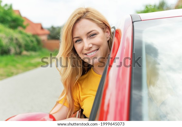 Happy beautiful young\
woman drives a car.
