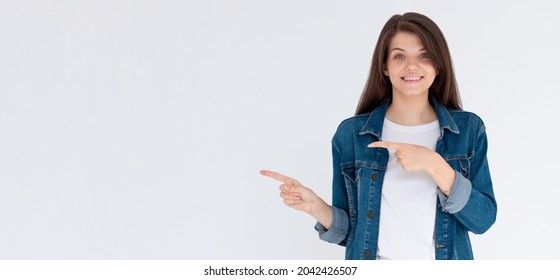 Happy Beautiful Young Woman Showing Way With Fingers