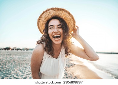 Happy beautiful young woman smiling at the beach side - Delightful girl enjoying sunny day out - Healthy lifestyle concept with female laughing outside  - Powered by Shutterstock