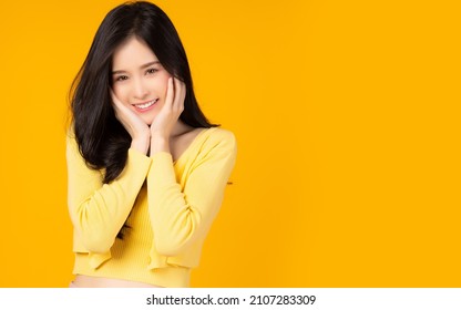 Happy beauty asian woman looking camera in excitement with happy and smile face Expressive facial expressions Beautiful girl act like a satisfied product She get shy Isolated on yellow background